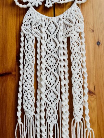 Weißes Makramee kombiniert mit einem hölzernen Blumenmuster Weißes Makramee kombiniert mit einem hölzernen Blumenmuster