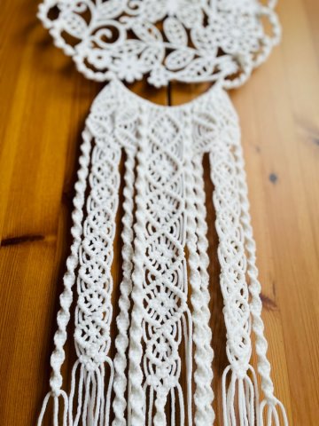 Weißes Makramee kombiniert mit einem hölzernen Blumenmuster Weißes Makramee kombiniert mit einem hölzernen Blumenmuster